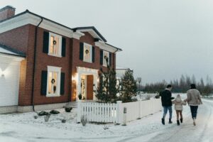 family outside home decorated for Christmas